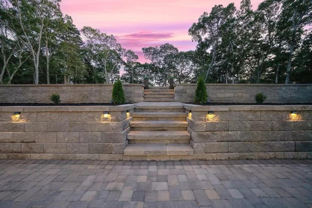 Illuminated retaining wall with integrated lighting and steps at sunset
